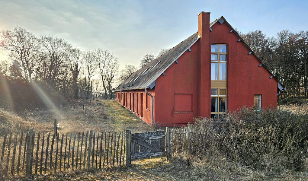 Das rote Kurshaus pergo mit Staketenzaun
